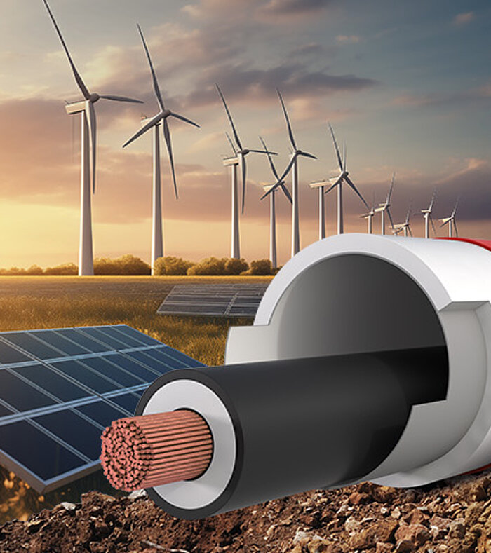 Symbolbild für Infrastruktur: Kabelschutzrohr im Querschnitt im Vordergrund, dahinter Solar- und Windanlagen bei Sonnenuntergang.