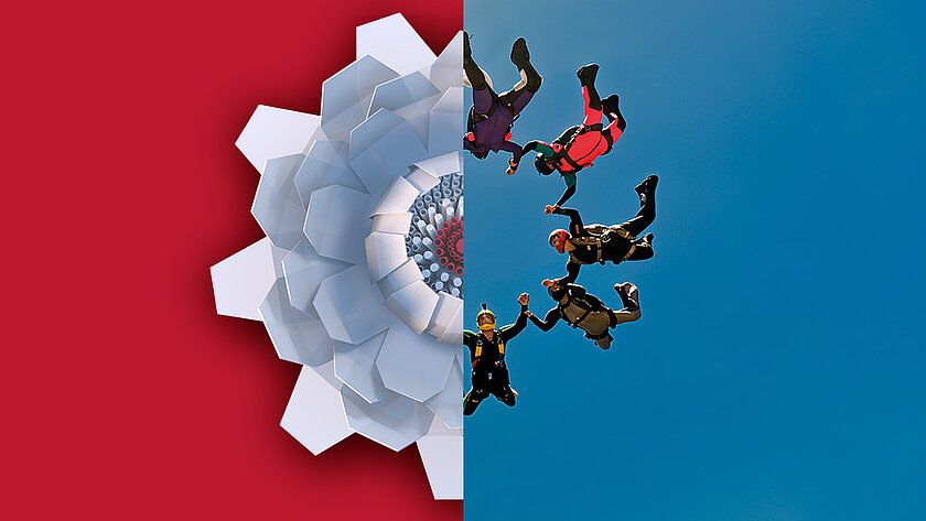 Halbierte Bildkomposition: Links ein roter Hintergrund mit einer aus weißen Kunststoffelementen geformten abstrakten Blüte, rechts ergänzen fünf Fallschirmspringern fallend vor blauem Himmel die Blütenform. Sie fassen sich an den Händen.