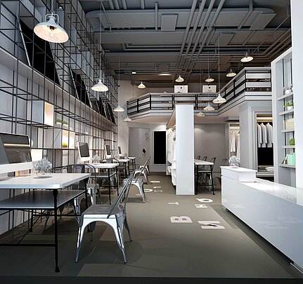Modern eingerichteter Arbeits- und Showroom mit hohen Decken, sichtbaren Leitungen und hängenden Lampen. Im Vordergrund stehen Tische mit Computern und Metallstühlen, im Hintergrund befinden sich Regale, Kleiderstangen und eine Galerie-Etage.