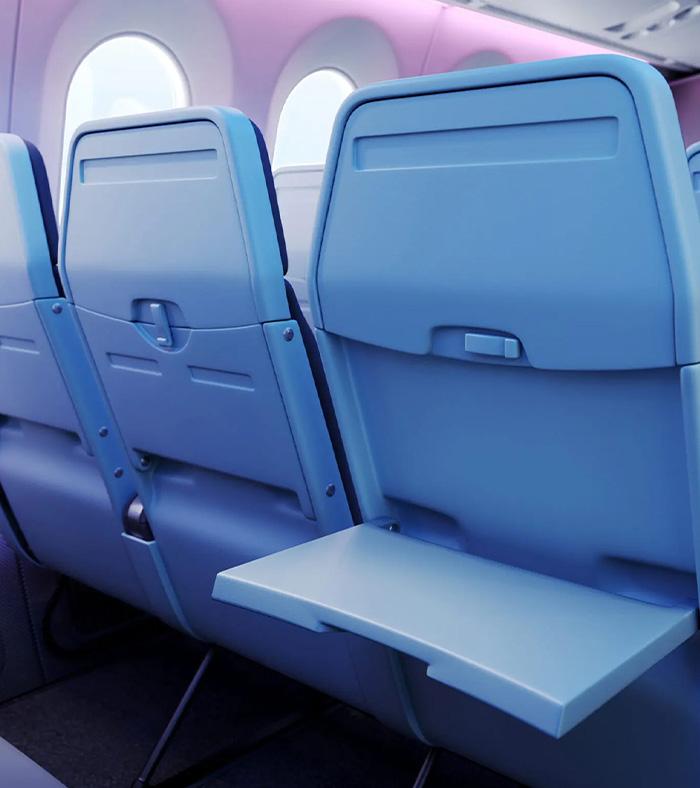Reihe moderner Flugzeugsitze mit blauen Sitzschalen und heruntergeklapptem Klapptisch vor einem Fenster.